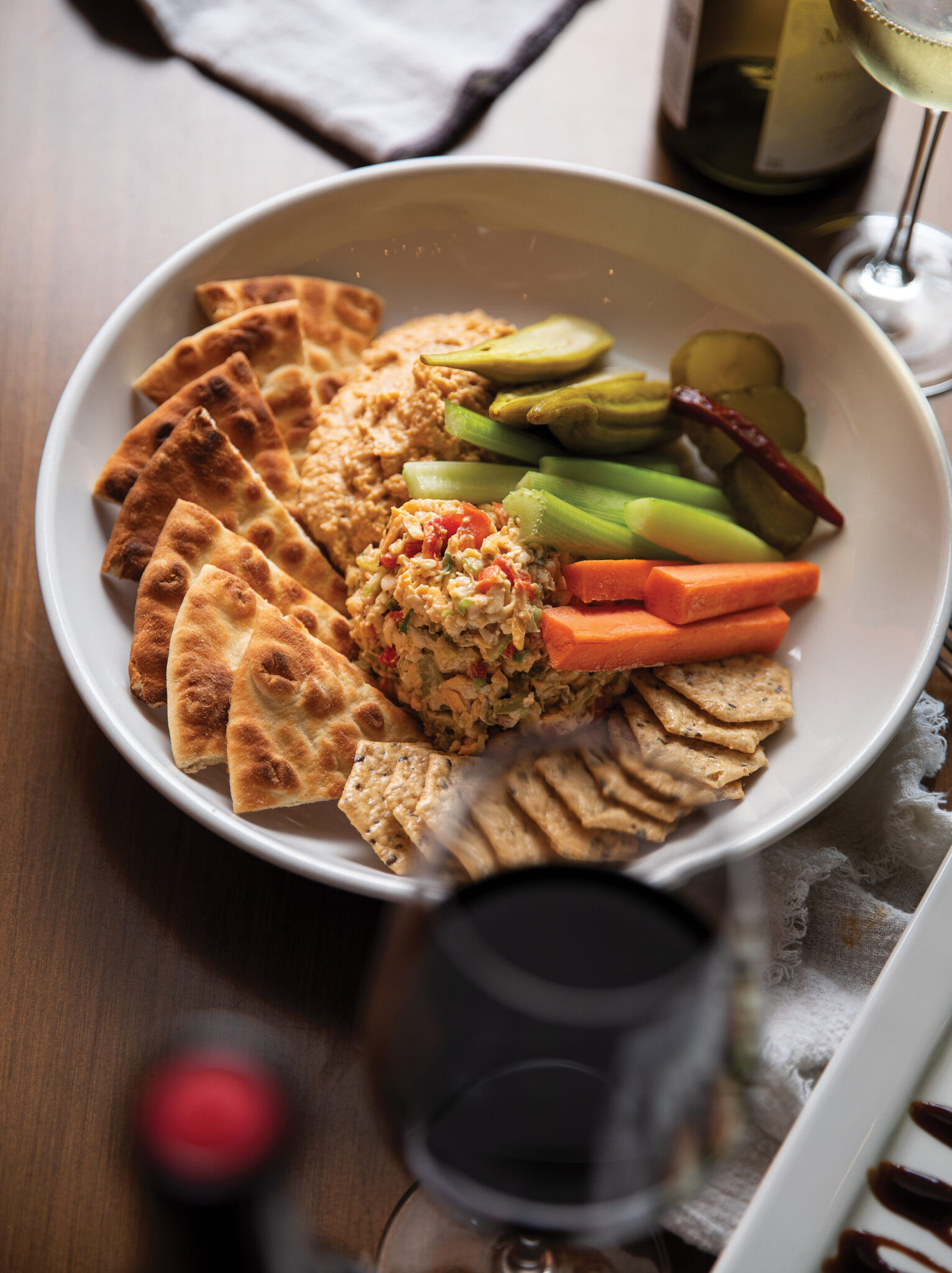 A sharing plate with pita, dip, and vegetables